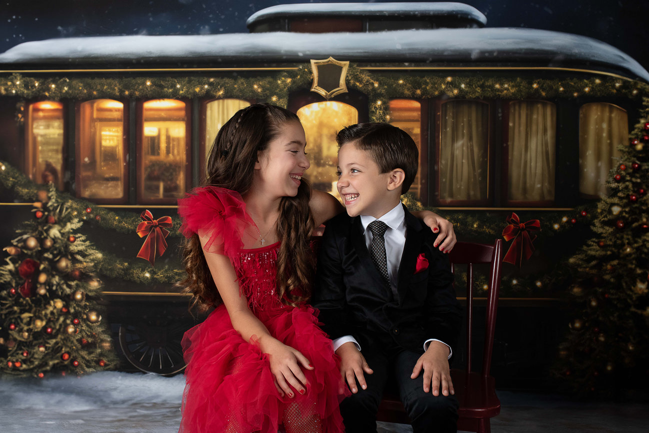 Siblings laughing at each other during their Christmas photos