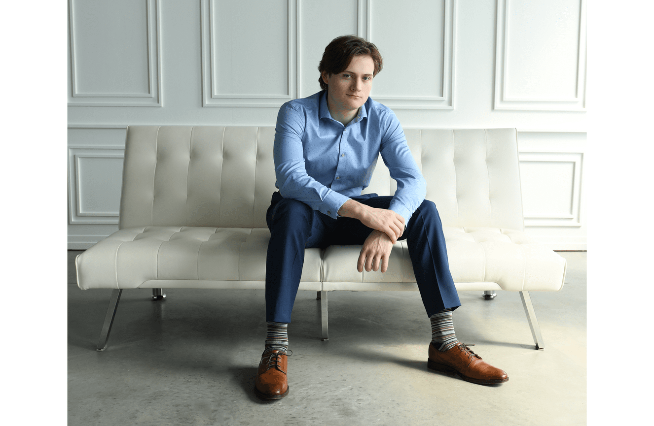 A smartly dressed teenager in the white studio at Kliks Photography.