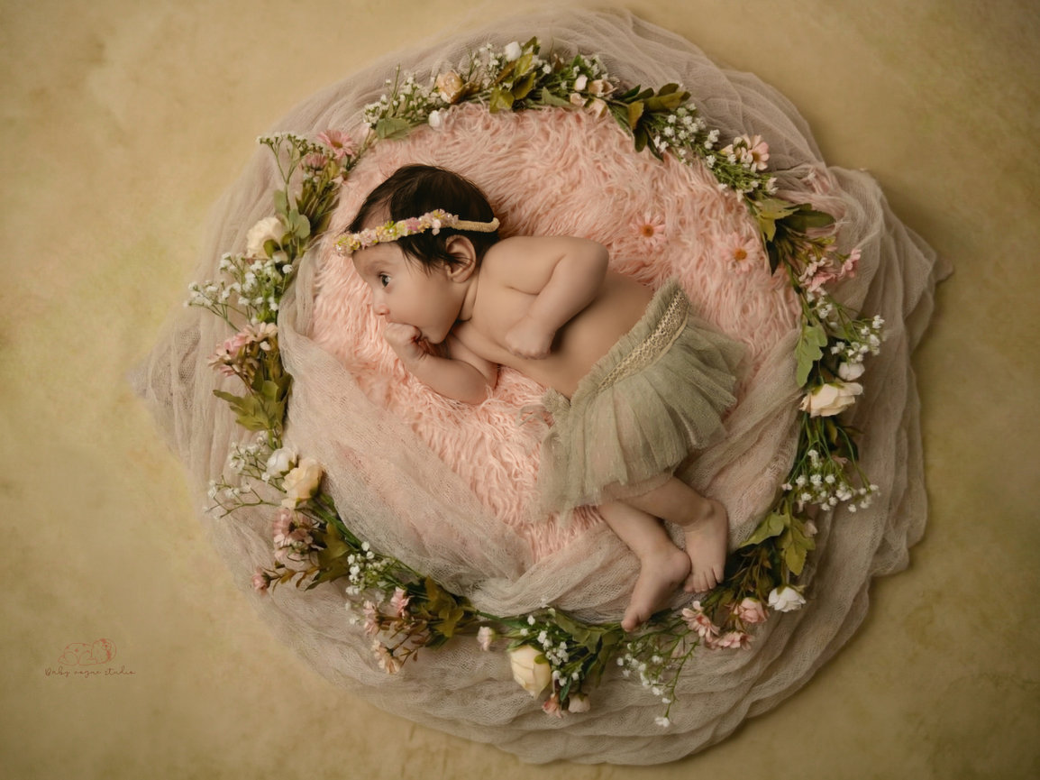 Sleeping baby on pink with floral wreath