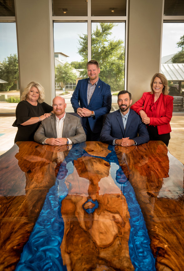 Photo of Group of business people sitting at head of table