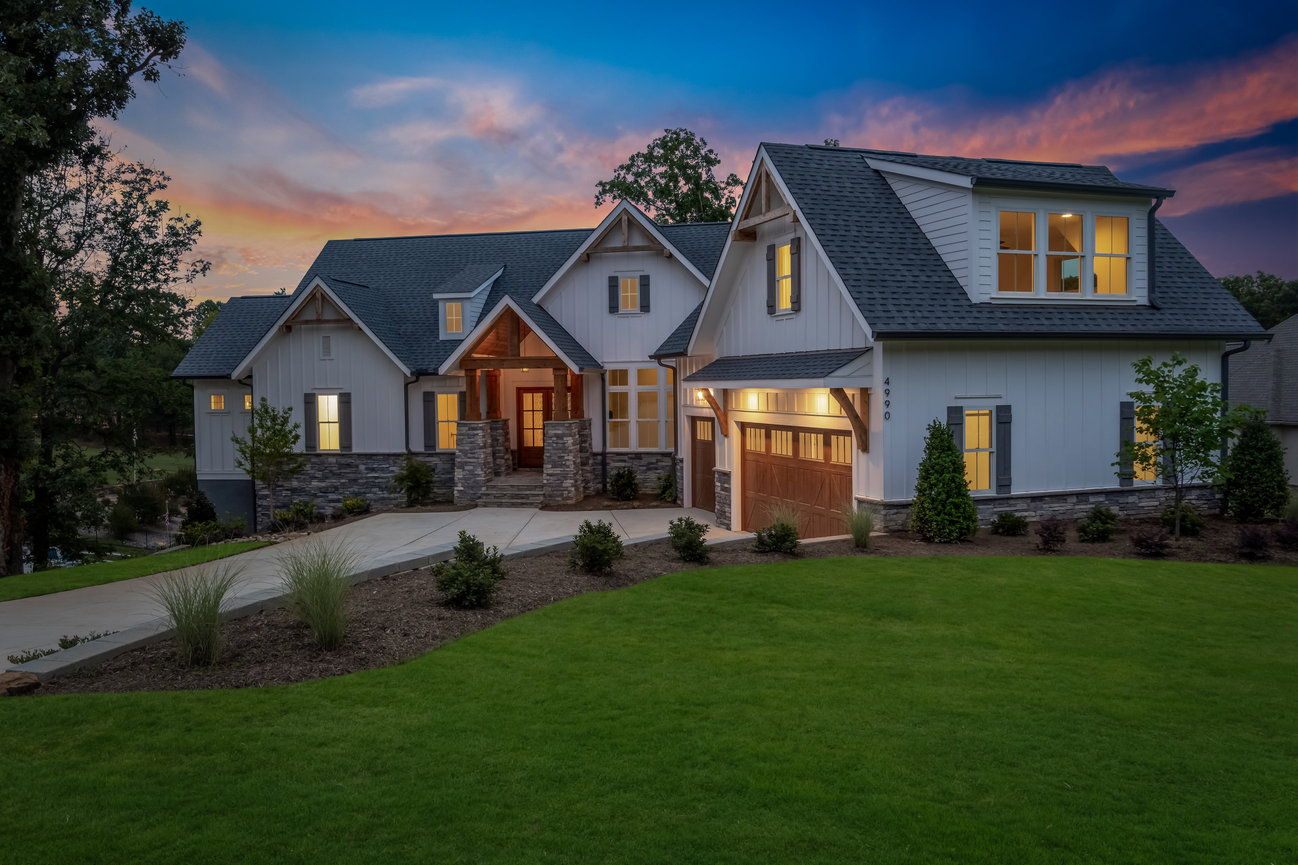 Modern suburban house at sunset with lit windows, Denver NC