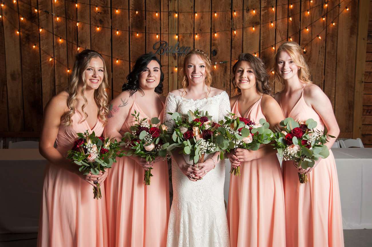 Boho bride with bridesmaids posing for picture.