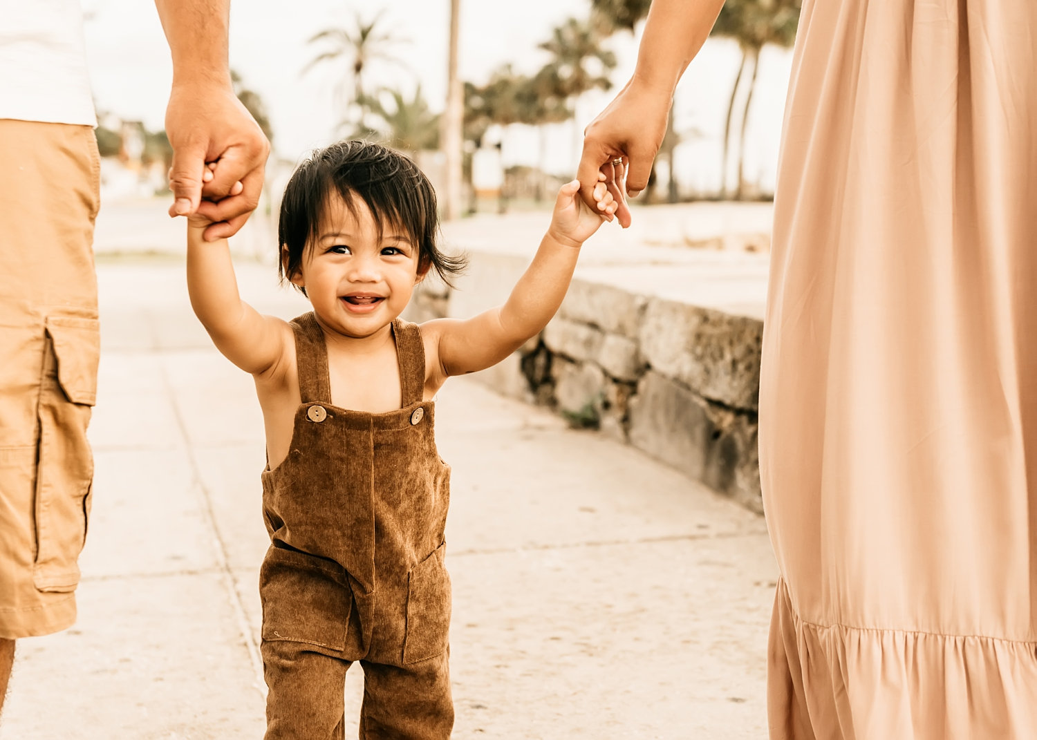 parents holding toddler boy's hands while he's walking, Saint Augustine Florida family photography